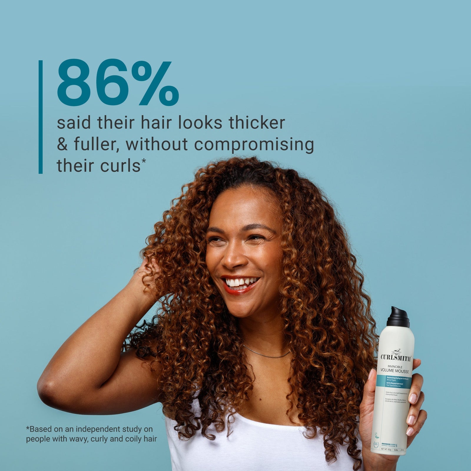 Woman with curly hair holding a bottle of 'Curlsheets' product against a blue background