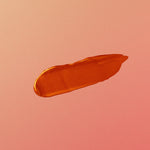 Orange makeup swatch on a pink background