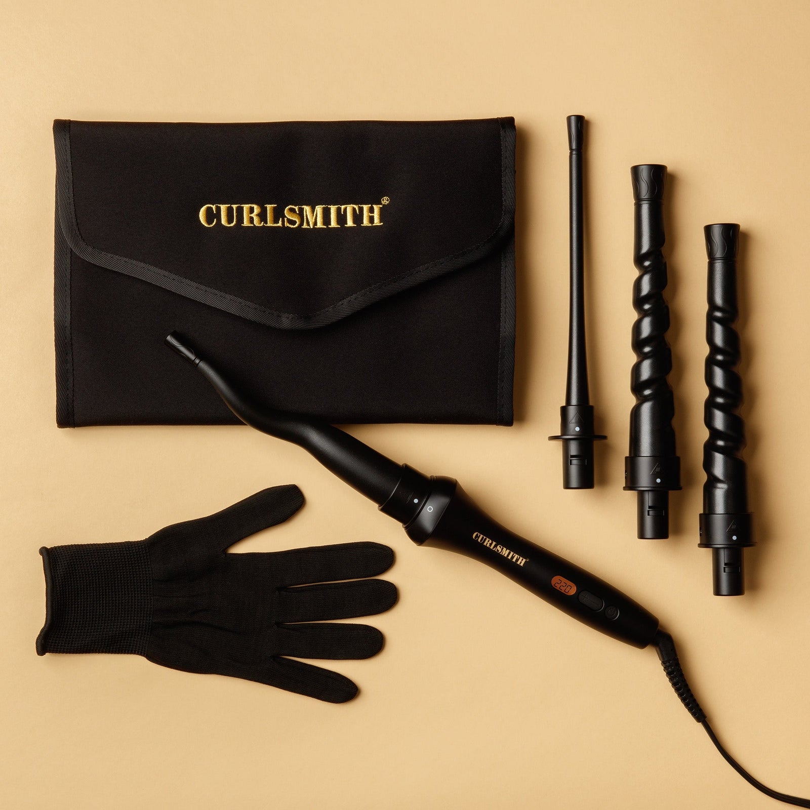 Curlsmith curling tool set with black case, glove, and multiple attachments on a beige background